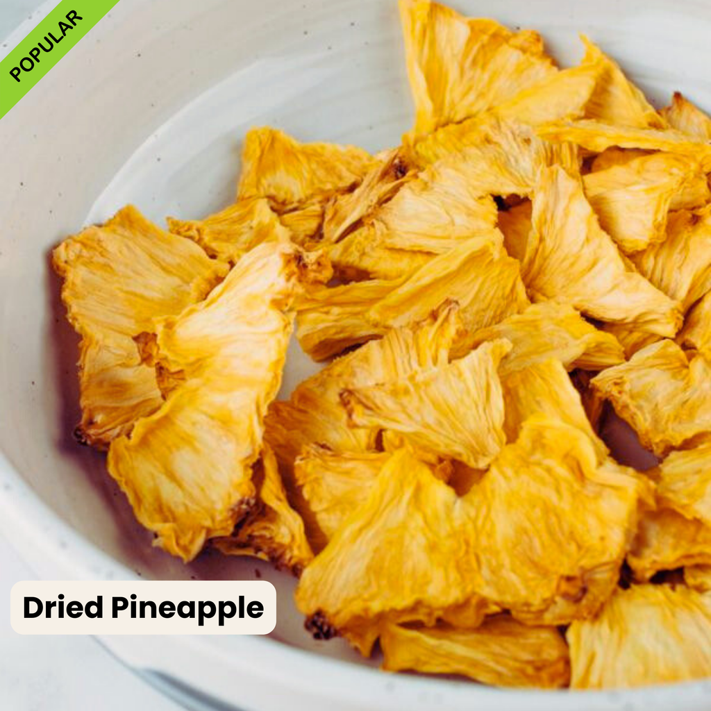 Close-up of golden Australian dried pineapple pieces in a white ceramic bowl. Naturally sweet, chewy, and 100% additive-free. A healthy tropical snack option