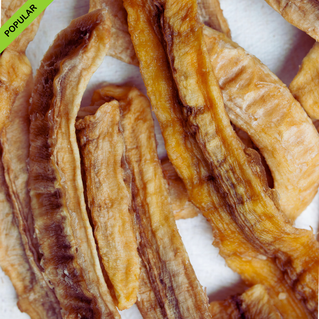 Close-up view of premium Australian dried banana longs dipped in lime juice, showing their natural golden-brown color and chewy texture. A ‘Popular’ banner is placed in the corner, highlighting customer demand.