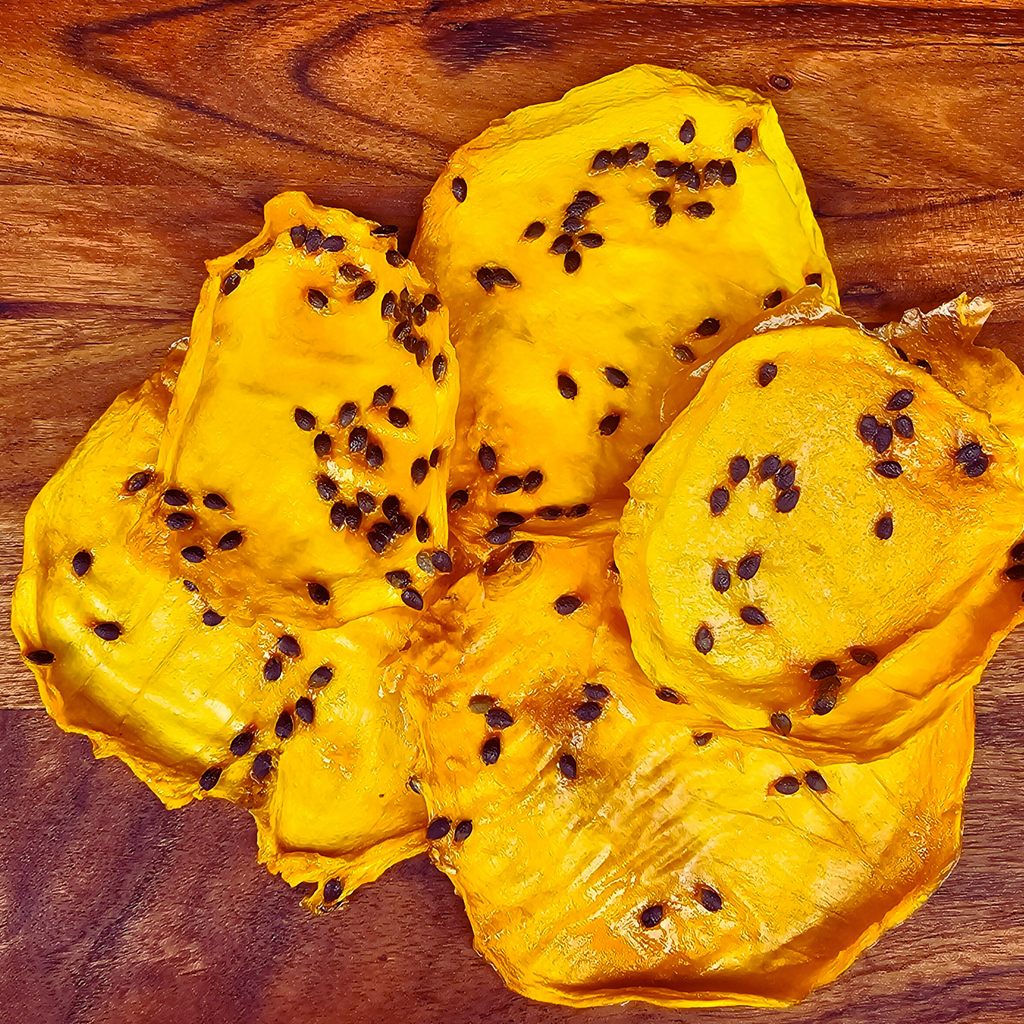 Close-up of Australian-grown dried mango with passionfruit pulp, featuring natural passionfruit seeds and chewy texture.
